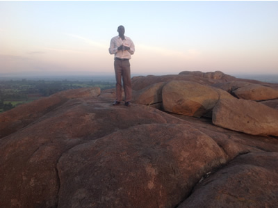 A tour guide at the apex of mwibale rock in Bungoma county . The rock whose circumference is 25 kilometers attracts both local and international tourists 